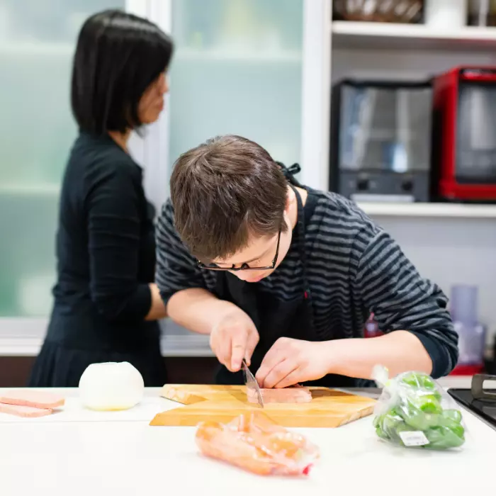 Disabled boy in cooking class learning how to make a meal