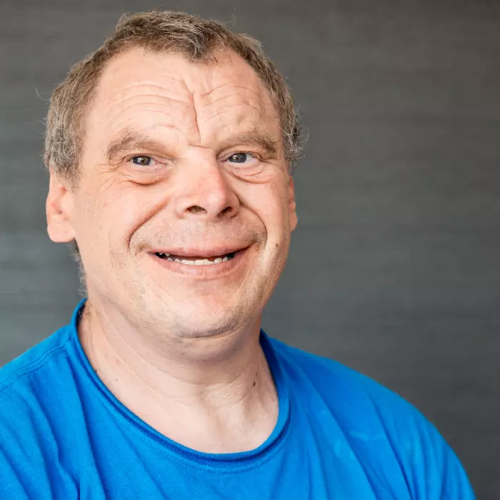 Disabled man smiling and looking past camera